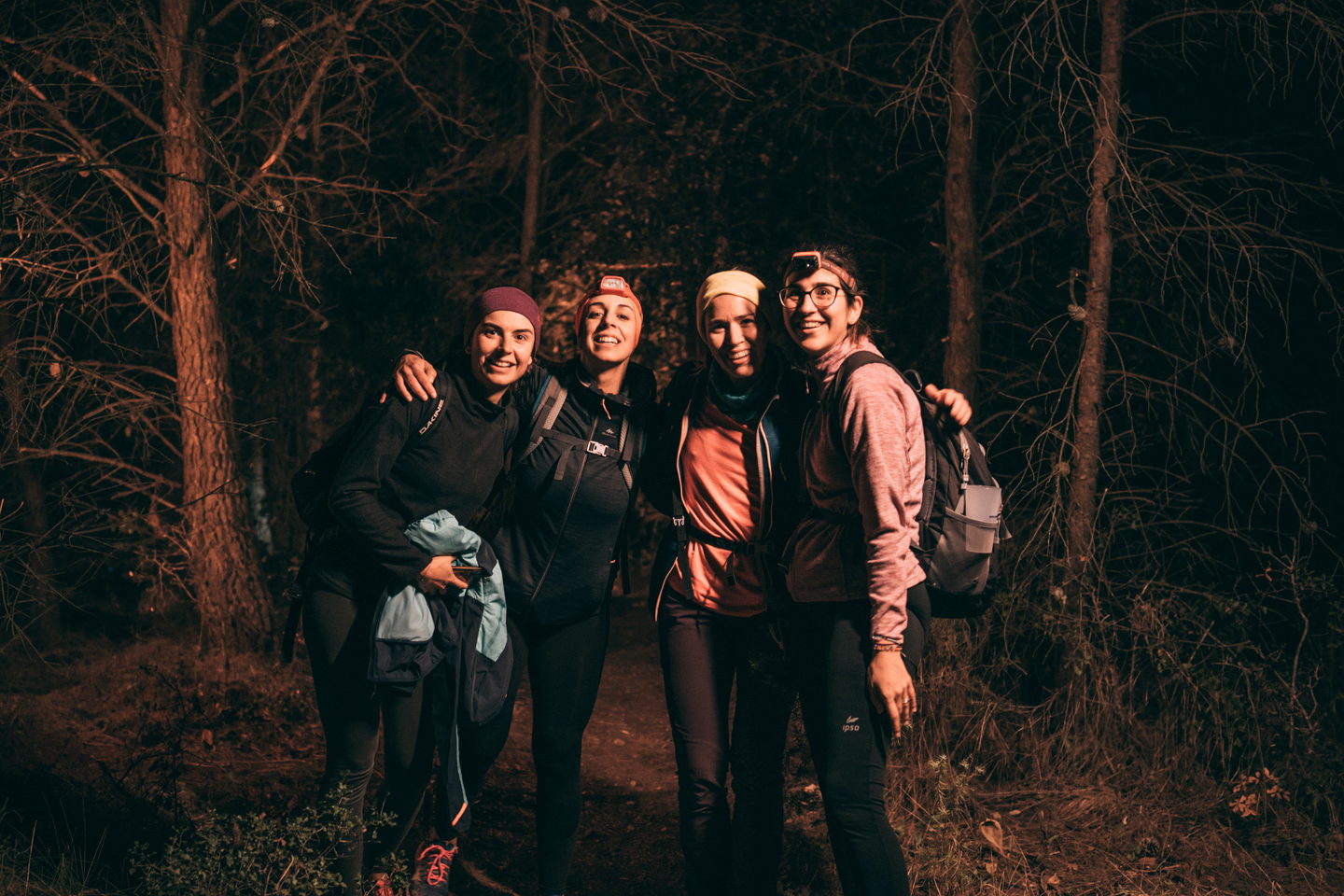 Grup de cinc corredors amb frontal rient al bosc